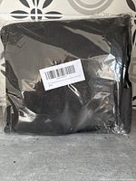 Black folded car windshield snow cover protector packaged in clear plastic.