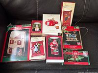 Photo of 8 Hallmark Keepsake Christmas ornaments in original boxes showing various designs including Santa, train, Christmas croc, house, red car, and Looney Tunes characters.