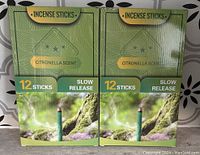 Two unopened green boxes of citronella scent incense sticks with slow release, each containing 12 sticks.