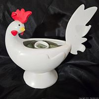 Front and side view of white ceramic rooster planter with red comb, holding floral foam inside.