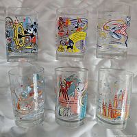 Six clear glasses displayed in two rows, featuring colorful vintage Disney cartoon images including Mickey Mouse, Bambi, Donald Duck, and other classic characters.