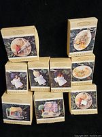 Full group of nine Hallmark Keepsake Showcase ornaments in original boxes stacked in a pyramid shape showing various animal and seasonal designs.