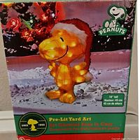 Original box showing Woodstock character with Christmas lights and Peanuts branding, with measurement indicating 18 inches tall.