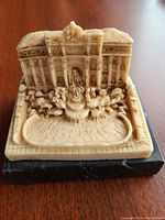 Front view of the vintage alabaster Trevi Fountain miniature showing overall shape, fountain basin, Neptune statue, and architectural elements on granite slab base.