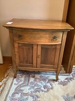 Full frontal view of antique wash stand showing drawer and two-door cabinet, wood finish visible.