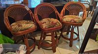 Three matching rattan bar stools side by side