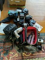 Overview of lot showing cameras, lenses, flashes and bags