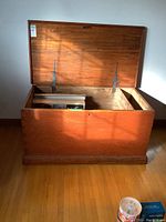 Open view of solid wood rustic chest showing inside and metal hinges holding the lid.