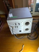 Rear and side view of Mordaunt Short MS409W subwoofer showing ports, power cable, control dials, and input/output connections.