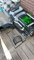 Folded mower on deck showing side discharge chute removed, grass bag frame detached
