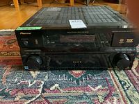 Front view of the Pioneer Elite VSX-84TXSi receiver showing the large dual knobs and red display panel with logos.