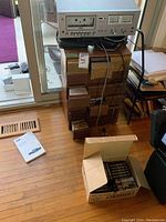 Overall view of Toshiba deck atop wooden storage boxes and cardboard box of new cassettes
