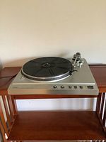 Full view of vintage Aurex turntable with black platter and controls on silver base.