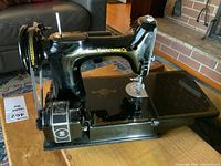 Left-front three-quarter view of sewing machine on wooden table