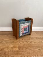 Magazine rack showing front fabric panel with patchwork design and wooden frame sides