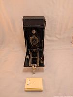 Front view of the No. 2 Brownie folding camera opened up showing the lens and shutter assembly.