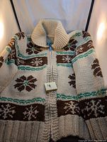 Front view of the vintage Cowichan sweater showing green and brown clover pattern on cream knit with full zipper and thick collar.