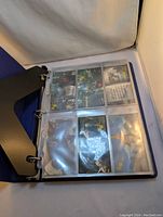Photo showing a page of 9 Monty Python & The Holy Grail trading cards in clear sleeves inside a binder.