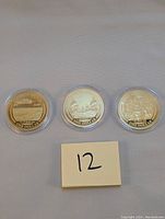 Three 2017 US one dollar proof coins displayed in protective clear capsules, showing front face with battle scenes and denomination 'One Dollar'.