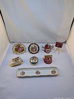 Full view of entire Limoges porcelain miniature set displaying plates, teapot, iron, trinket box, cup and tray