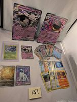 Wide shot showing all cards in the lot, including two jumbo cards of Houndstone and Banette, multiple smaller cards including a holographic Absol EX.