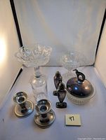 Lot overview showing pressed glass candy dishes, pewter candle holders, Viking pewter salt and pepper shakers, and frosted glass lidded dish with pewter greyhound figurine lid.