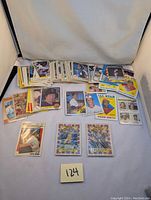 Various vintage baseball cards spread out, multiple players shown, some cards in protective sleeves.