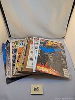 Stack of vintage comic books featuring multiple titles and characters like Batman and others.