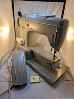 Front and side angled view of the Pfaff 360 sewing machine showing foot pedal and machine body.
