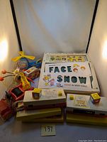 Image of Fisher Price school desk, movie viewer cartridges, and Queen Buzzy Bee toy