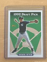Front of 1993 Topps #98 Derek Jeter 1992 Draft Pick baseball card showing player in pitching pose with green and beige background.