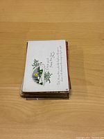 Stack of vintage New Year postcards viewed from top, showing flower design with handwritten message.