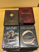 Photo of various DVD box sets and cases from Lord of the Rings and Harry Potter series showing front covers with artwork and titles clearly visible