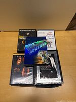 Photo showing a stack of DVDs with titles Back to the Future, Forrest Gump, 8 Mile, The Sixth Sense, and American Gangster visible on top