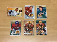 Six 1951 Bowman football cards laid out on a wooden surface showing front images of players Lynn Chandnois, John Strzykalski, Louis Creekmur, Jon Baker, J.P. Pete Stout, and Paul Lipscomb.