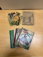 Top view of all six children's books showing titles and condition on covers, including Doggie Pranks, Granny's Wonderful Chair, Black Beauty, Puss in Boots, and two others.