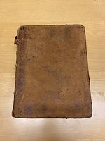Top view of the Bible cover showing extensive wear and water damage on the brown leather binding.