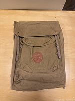 Full view of the vintage Boy Scouts of America canvas backpack showing the overall structure, leather straps, and flap.