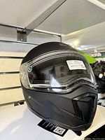Front-angle view of matte black Trans snowmobile helmet size XL with integrated clear visor.