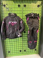 Full view of jacket and pants hung on display grid.