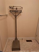 Full view of the upright vintage beam scale showing platform, support column, beam mechanism and height.