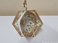 Hexagonal Nippon teacup and saucer, showing interior floral design and gold trim.