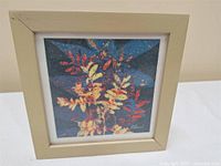 Frontal image of framed paper art featuring colorful abstract botanical design in 7x7 beige frame.