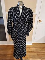 Front view of black and white patterned Japanese kimono displayed on mannequin.