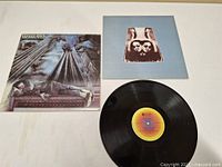 Album cover, vinyl record, and inner sleeve laid out on surface