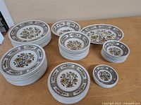 Full view of the vintage dinnerware set showing stacks of plates and bowls with Dorset floral pattern.