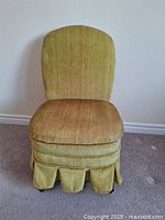 Front view of the vintage slipper chair showing gold upholstery and rounded backrest.