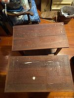 Top view showing wood surface with wear marks including paint spots and scratches on the two side tables.