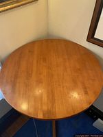 Top view of a round wooden table with natural wood grain finish.