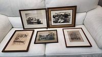 All 5 framed black and white prints displayed on couch, showing the variety of scenes and frames
